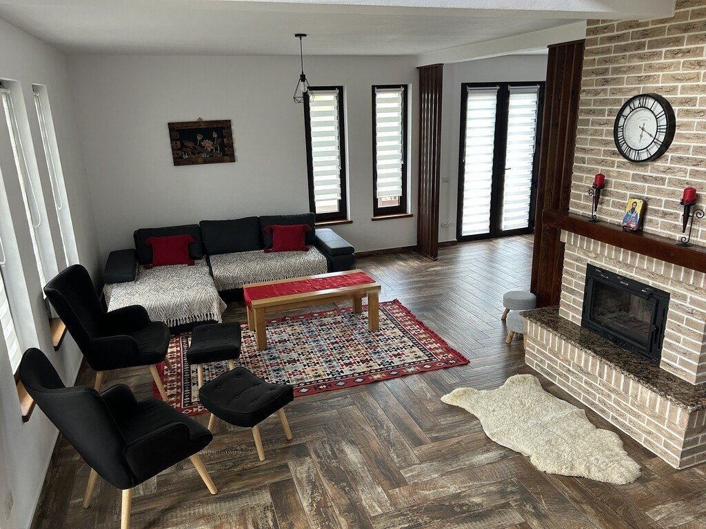 Salonul vilei Cacica Holiday cu șemineu și canapea